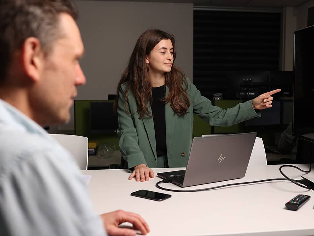 medewerker van Sparta wijst een kandidaat de weg tijdens een gesprek op kantoor
